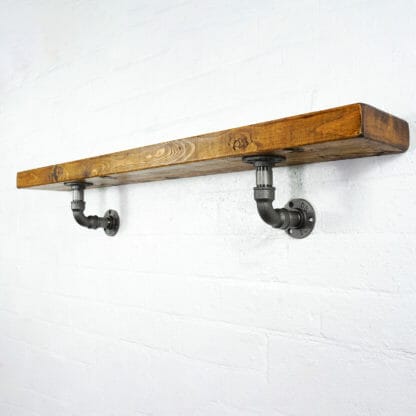 Raw steel industrial pipe shelving brackets with reclaimed wood scaffolding board shelf