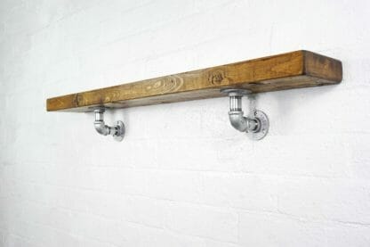 Galvanised industrial pipe shelving brackets with reclaimed wood scaffolding board shelf